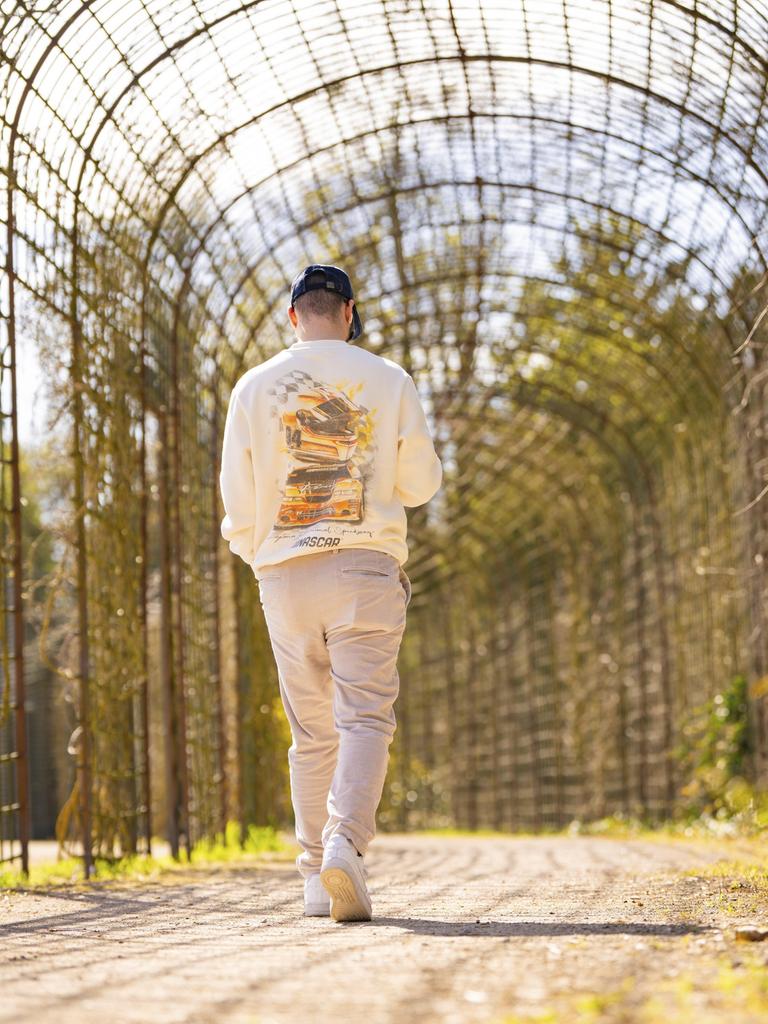 Ein Mann geht durch einen Gittertunnel im Park Ein Mann geht durch einen Gittertunnel im Park