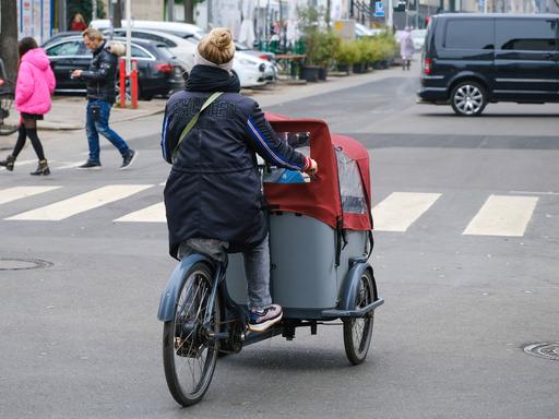 Eine Frau fährt auf einem Lastenfahrrad in Düsseldorf.