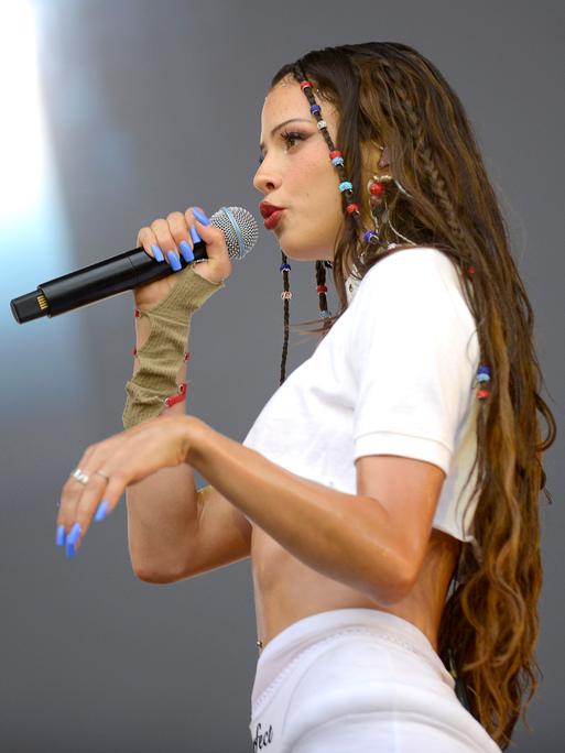 Nina Chuba singt in ein Mikrofon. 