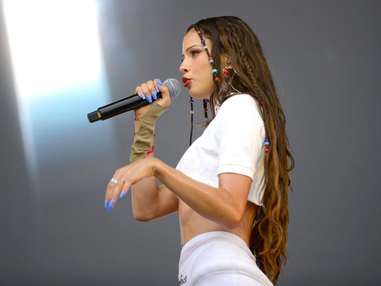 Nina Chuba singt in ein Mikrofon. 