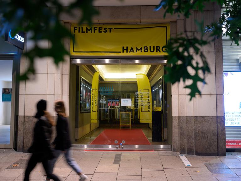 Zwei Frauen gehen vor dem Passage-Kino in der Mönckebergstraße vorbei, wo mit Plakaten auf das "Filmfest Hamburg" hingewiesen wird.