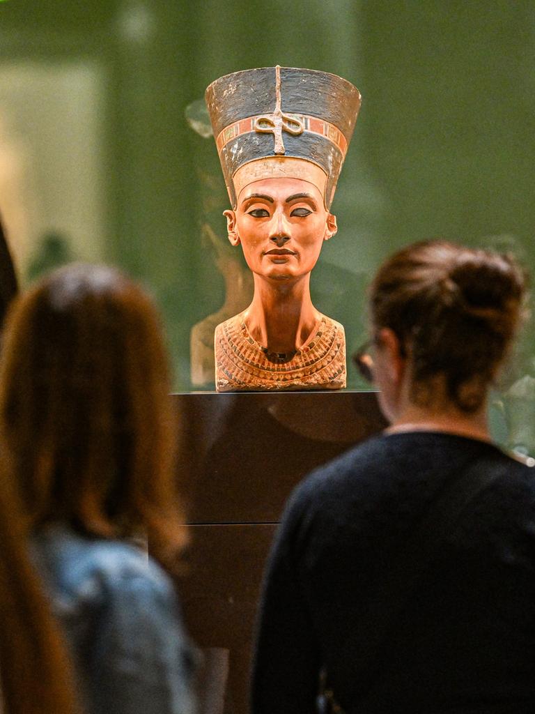 Die Büste der Nofretete wird von Besuchern und Besucherinnen im Museum in Berlin betrachtet
