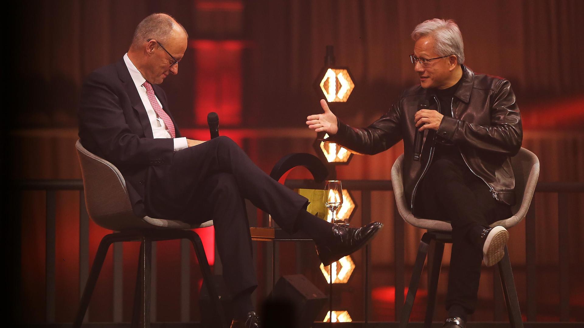 Friedrich Merz und Jensen Huang sitzen nebeneinander auf einer Bühne und sprechen miteinander. Friedrich Merz und Jensen Huang sitzen nebeneinander auf einer Bühne und sprechen miteinander.