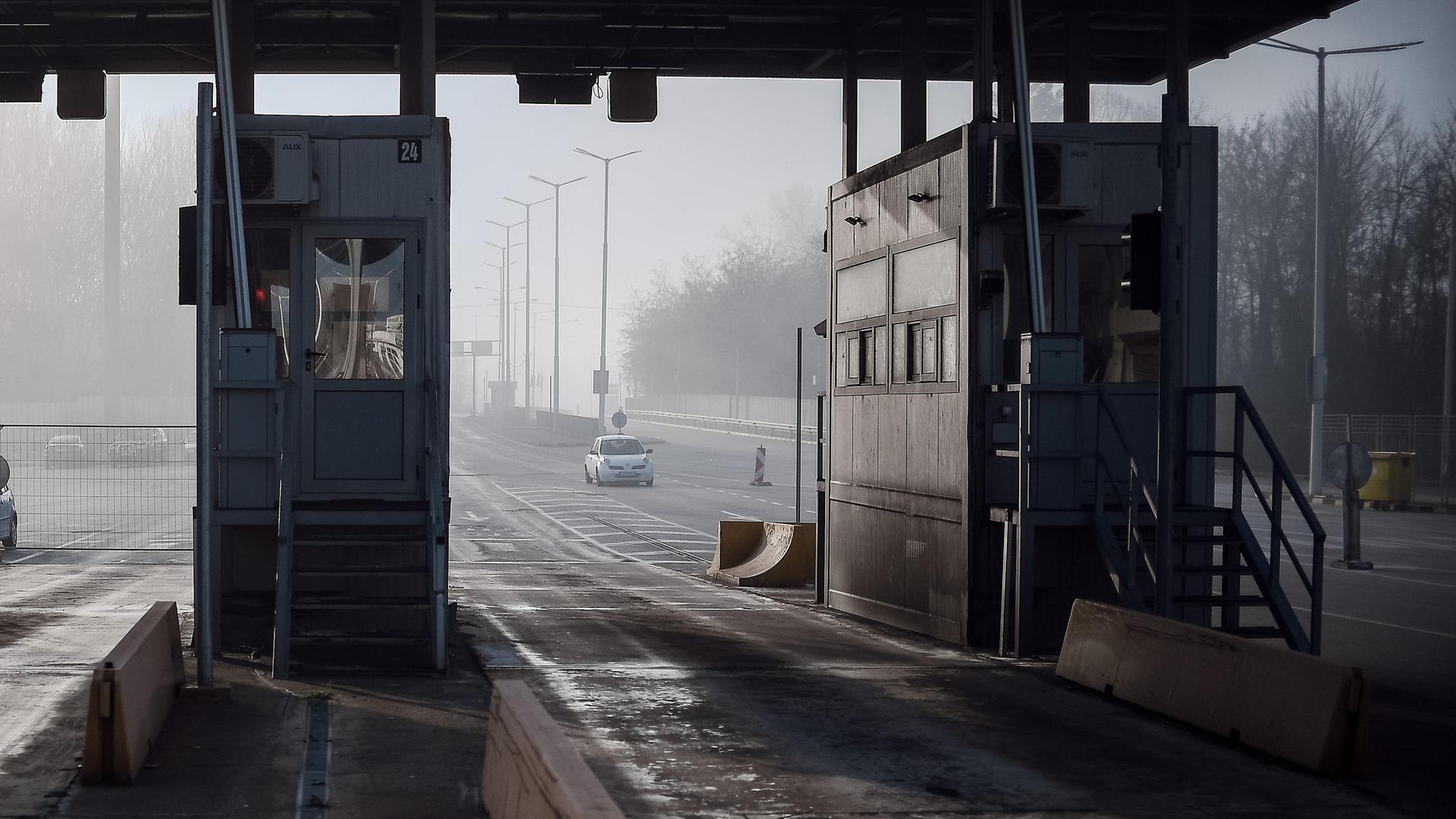 Man sieht eine freie Durch-Fahrt zwischen 2 leeren Grenz-Häuschen.