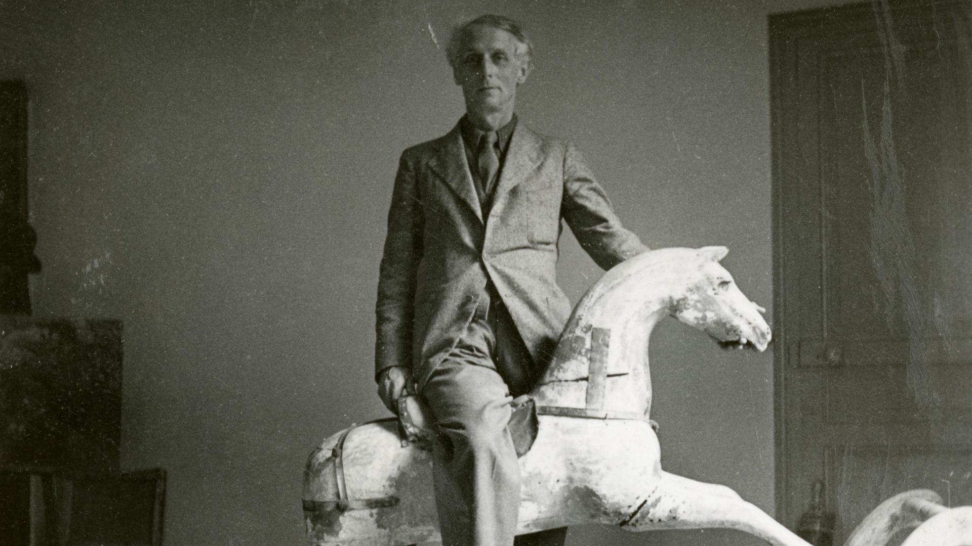 Schwarzweißfoto. Max Ernst mit Schaukelpferd.
