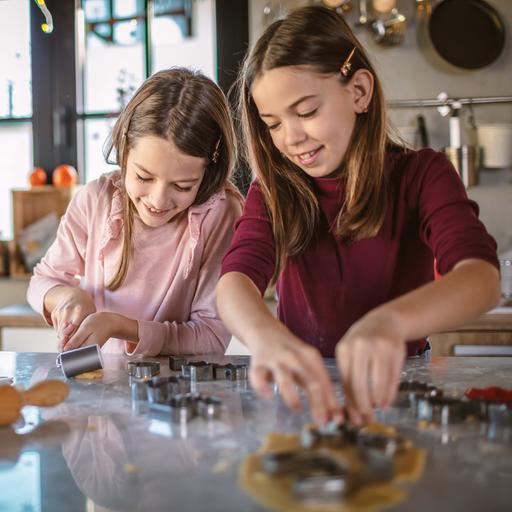 zwei Mädchen in der Küche beim Plätzchenausstechen