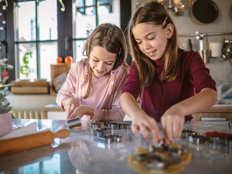 zwei Mädchen in der Küche beim Plätzchenausstechen