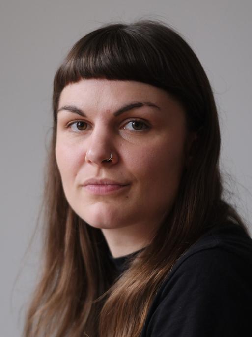 Susanne Siegert schaut in die Kamera. Sie hat dunkelbraunes Haar und trägt einen silbernen Nasenring.