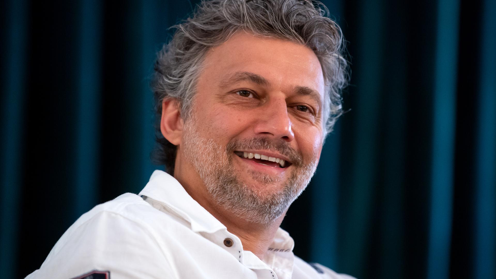Jonas Kaufmann, Opernsänger (Tenor), in weißem Hemd bei einem Pressegespräch.