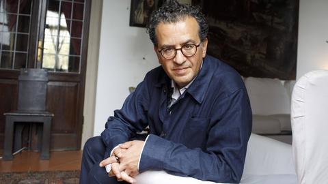 Porträt von Hisham Matar, der in einem Sessel sitzt und zugewandt in die Kamera blickt Porträt von Hisham Matar, der in einem Sessel sitzt und zugewandt in die Kamera blickt