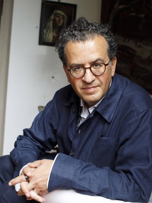Porträt von Hisham Matar, der in einem Sessel sitzt und zugewandt in die Kamera blickt