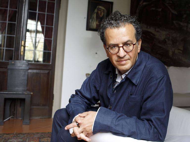 Porträt von Hisham Matar, der in einem Sessel sitzt und zugewandt in die Kamera blickt