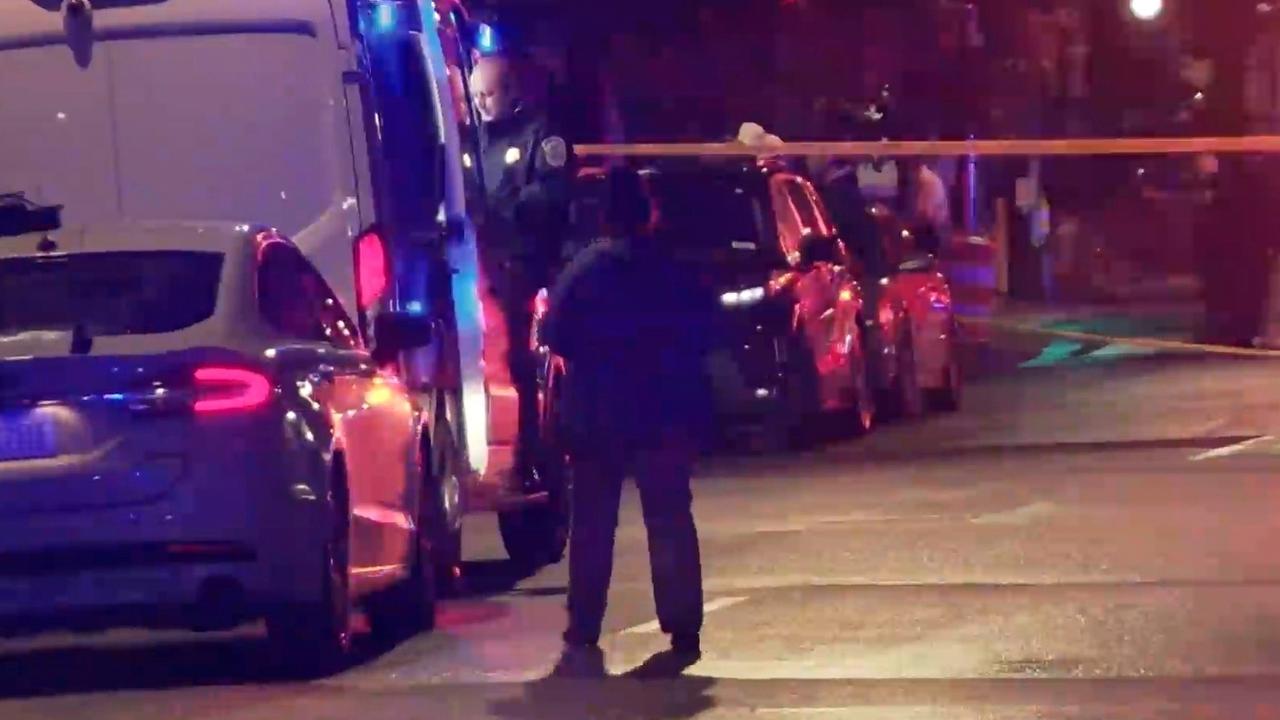 Blick auf den abgesperrten Tatort in Washington. Es ist dunkel. Ein Passant steht vor mehreren Fahrzeugen. Im Hintergrund ist Absperrband zu sehen. Blick auf den abgesperrten Tatort in Washington. Es ist dunkel. Ein Passant steht vor mehreren Fahrzeugen. Im Hintergrund ist Absperrband zu sehen.