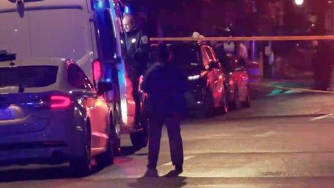 Blick auf den abgesperrten Tatort in Washington. Es ist dunkel. Ein Passant steht vor mehreren Fahrzeugen. Im Hintergrund ist Absperrband zu sehen.