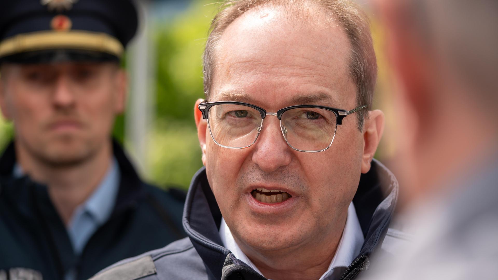 Bundesinnenminister Alexander Dobrindt (CSU) steht bei einem Besuch auf der Autobahn A93 zwischen Deutschland und Österreich vor Presseleuten und spricht.