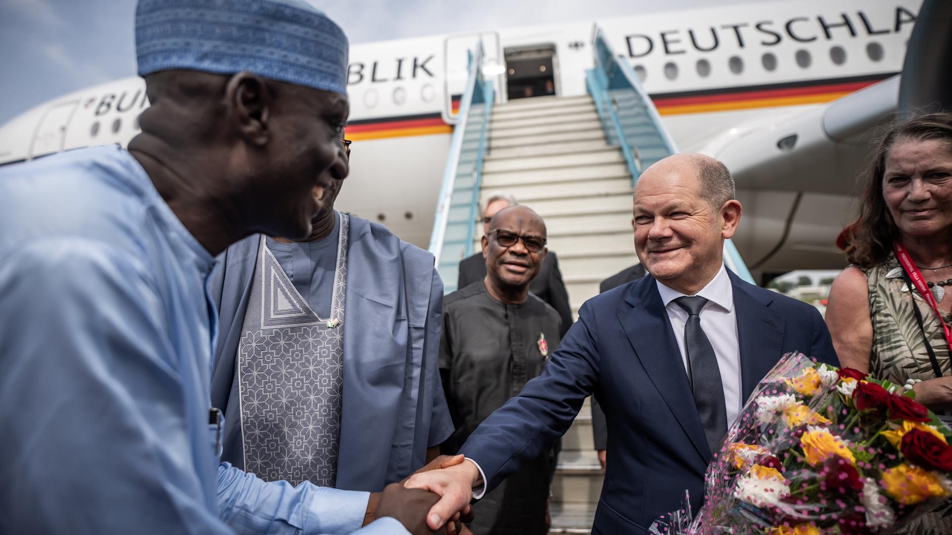 Bundeskanzler Olaf Scholz (SPD) wird in Nigeria begrüßt, mit Blumen und militärischen Ehren.