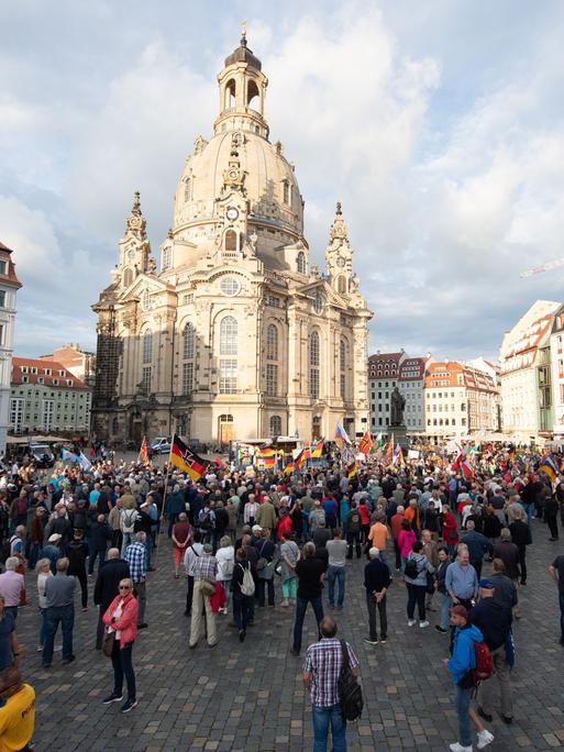 Teilnehmer stehen während einer Kundgebung der islam- und ausländerfeindlichen Pegida-Bewegung mit Fahnen auf dem Neumarkt.