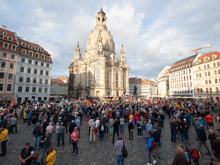 Teilnehmer stehen während einer Kundgebung der islam- und ausländerfeindlichen Pegida-Bewegung mit Fahnen auf dem Neumarkt.