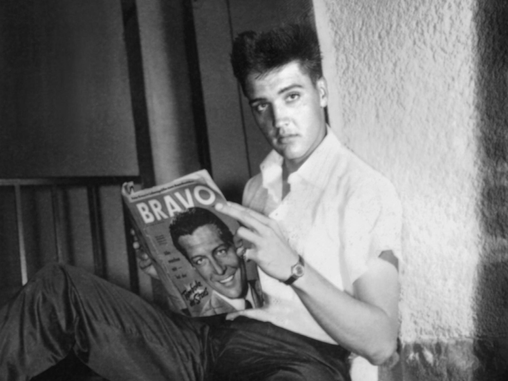 Der US-Sänger Elvis Presley in seinem möbilierten Zimmer in Bad Nauheim während der Stationierung als US-Soldat. Er blättert in einer Ausgabe der Jugendzeitschrift "Bravo". Das Foto ist schwarz-weiß. Der US-Sänger Elvis Presley in seinem möbilierten Zimmer in Bad Nauheim während der Stationierung als US-Soldat. Er blättert in einer Ausgabe der Jugendzeitschrift "Bravo". Das Foto ist schwarz-weiß.