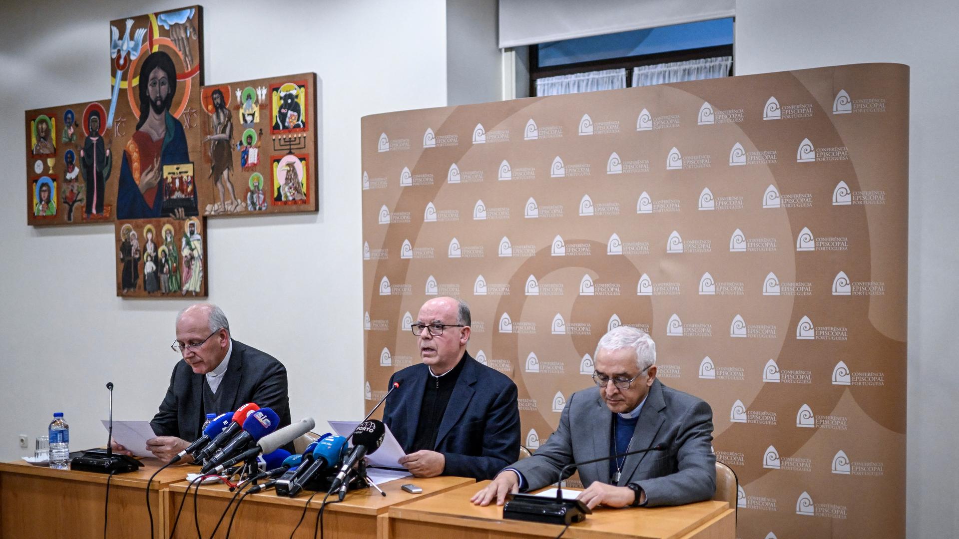 Jose Ornelas Carvalho (r), Bischof von Leiria-Fatima und Präsident der Bischofskonferenz, Virgilio Antunes (l), sein Stellvertreter und Bischof on Coimbra, und Manuel Barbosa (Mitte), Sekretär der Bischofskonferenz sitzen an einem Tisch. Schräg hinter ihnen an der Wand hängt ein Kreuz mit einem Bild von Jesus Christus. Jose Ornelas Carvalho (r), Bischof von Leiria-Fatima und Präsident der Bischofskonferenz, Virgilio Antunes (l), sein Stellvertreter und Bischof on Coimbra, und Manuel Barbosa (Mitte), Sekretär der Bischofskonferenz sitzen an einem Tisch. Schräg hinter ihnen an der Wand hängt ein Kreuz mit einem Bild von Jesus Christus.