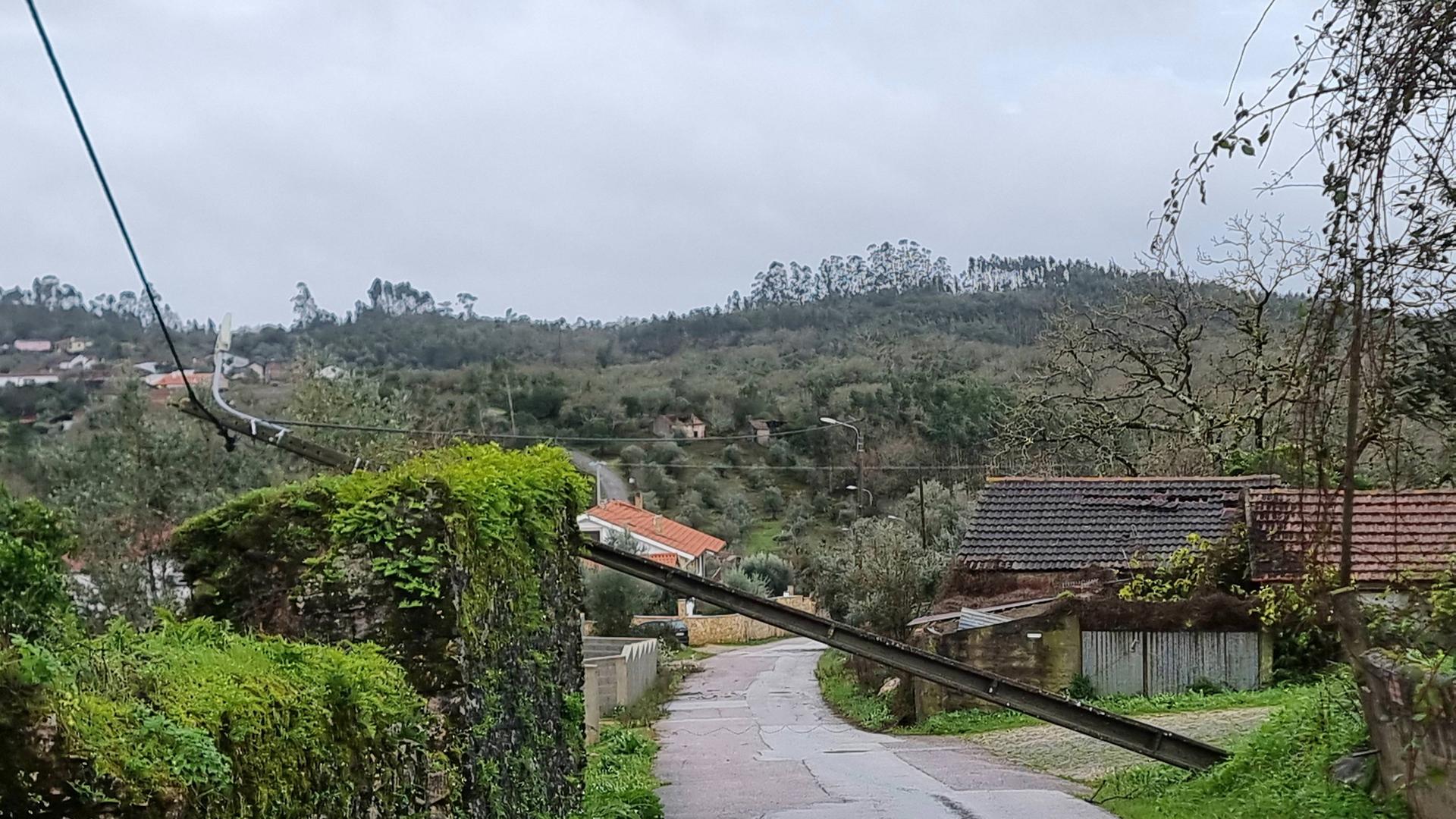 Über einer Straße in Portugal liegt ein umgeknickter Strommast.