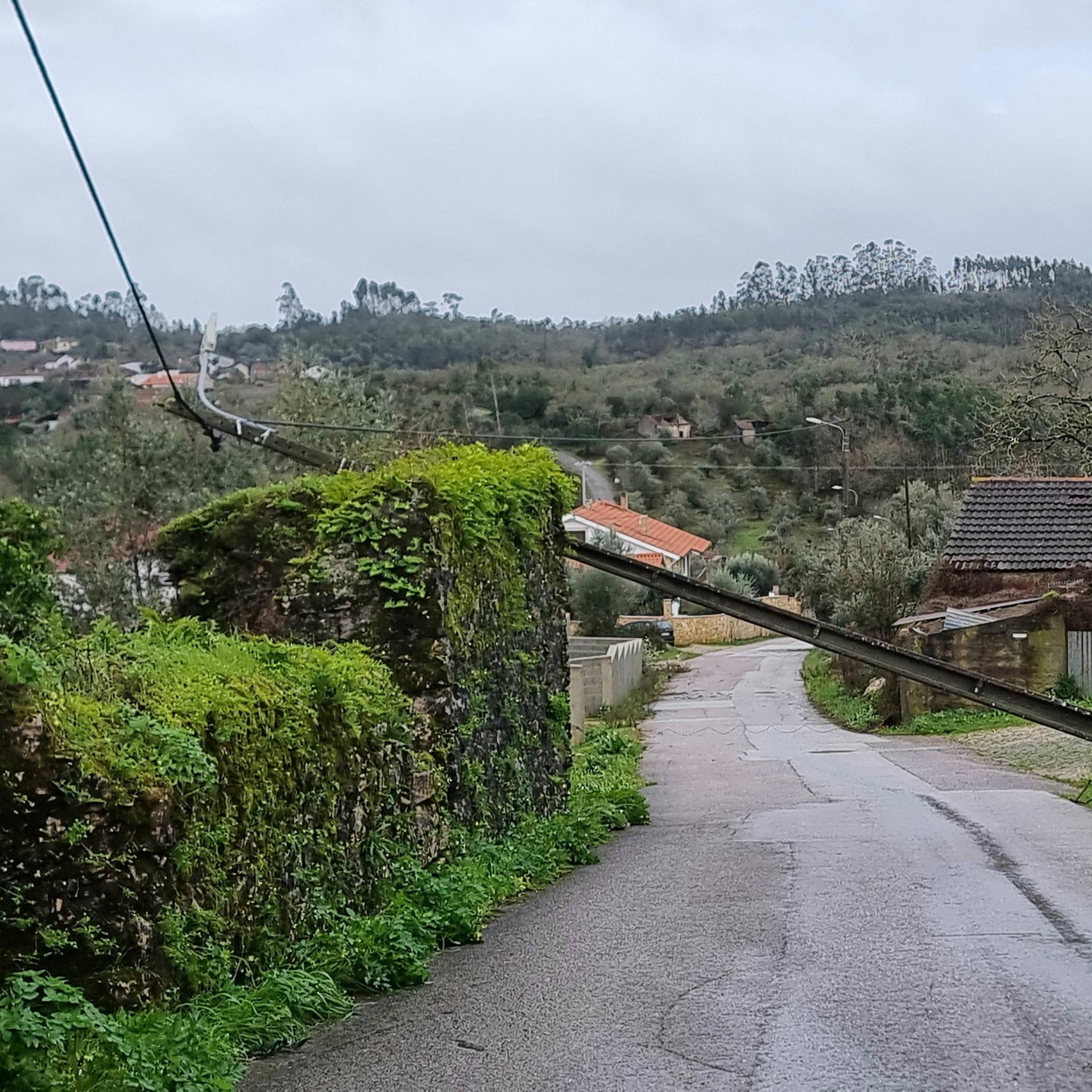 Über einer Straße in Portugal liegt ein umgeknickter Strommast.