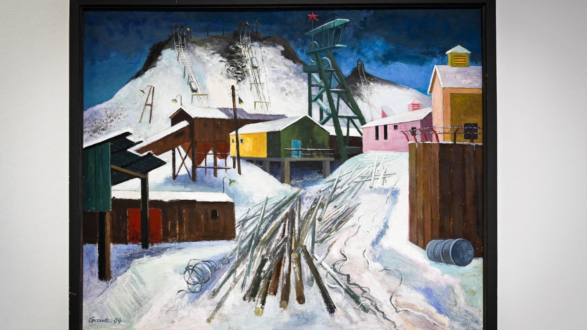 Auf einem Ölgemälde sind Gebäude eines Bergbau-Schachts an einem beschneiten Hang zu sehen.  Auf einem Ölgemälde sind Gebäude eines Bergbau-Schachts an einem beschneiten Hang zu sehen.