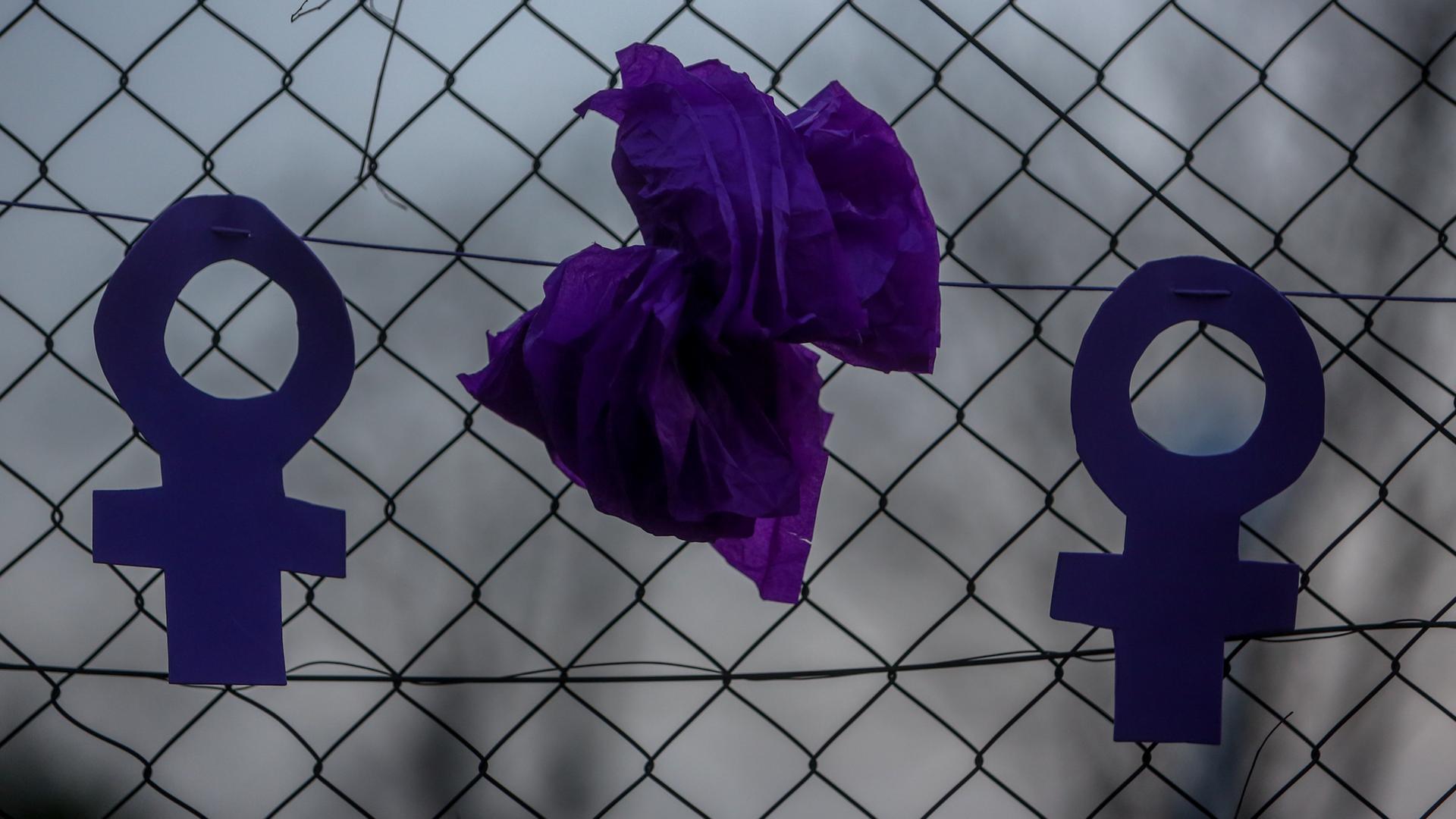 Zwei feministische Symbole hängen an einem Zaun während einer Kundgebung für Gleichberechtigung vor dem Frauentag. Zwei feministische Symbole hängen an einem Zaun während einer Kundgebung für Gleichberechtigung vor dem Frauentag.