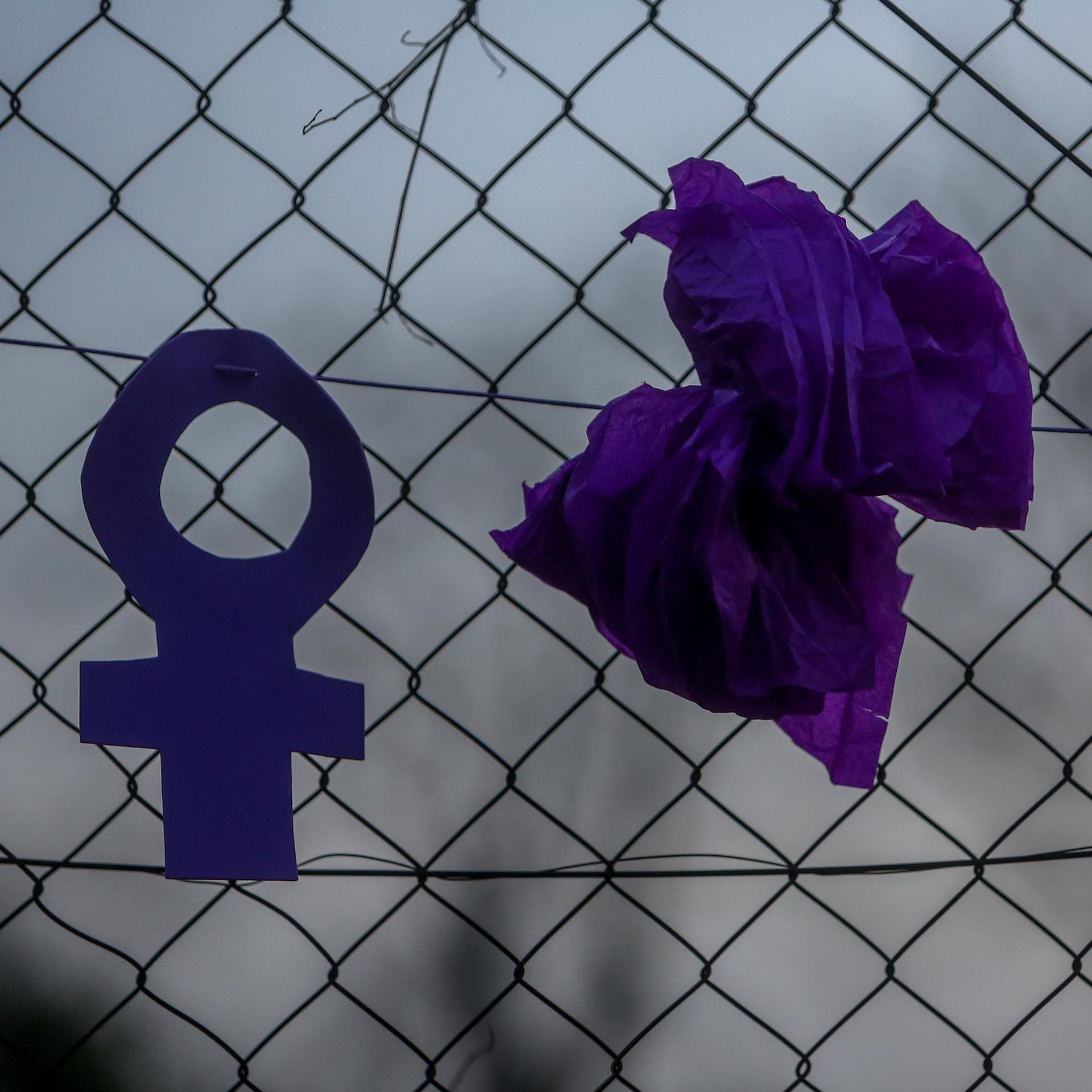 Zwei feministische Symbole hängen an einem Zaun während einer Kundgebung für Gleichberechtigung vor dem Frauentag.