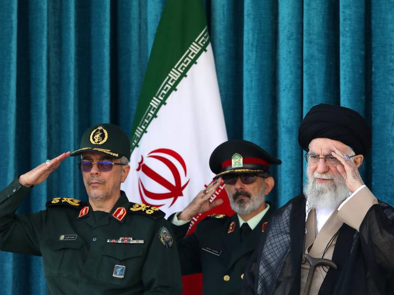 Irans oberster geistlicher Führer Ajatollah Ali Chamenei steht neben zwei Militärangehörigen.