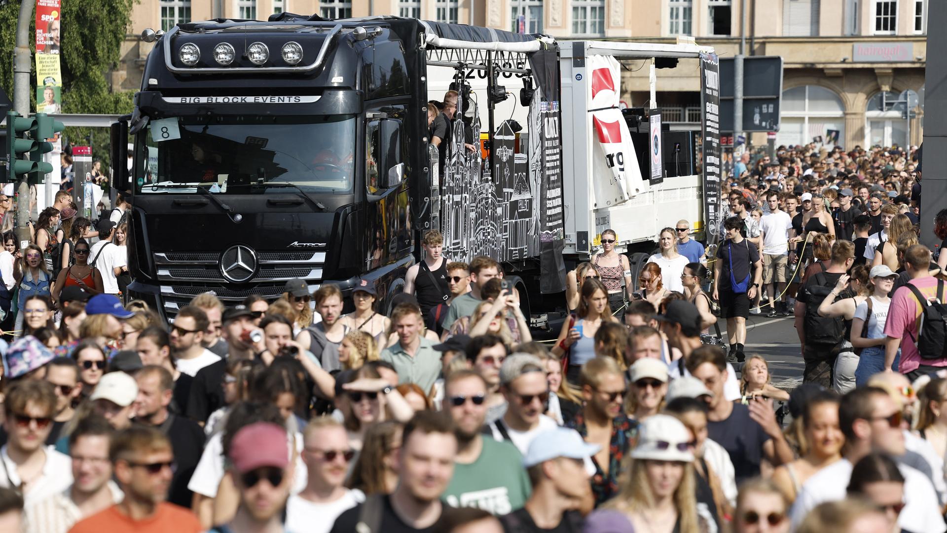 Ein Demonstrationszug mit tausenden Menschen in den Straßen von Dresden. Mitfahrende LKW beschallen die Großveranstaltung.