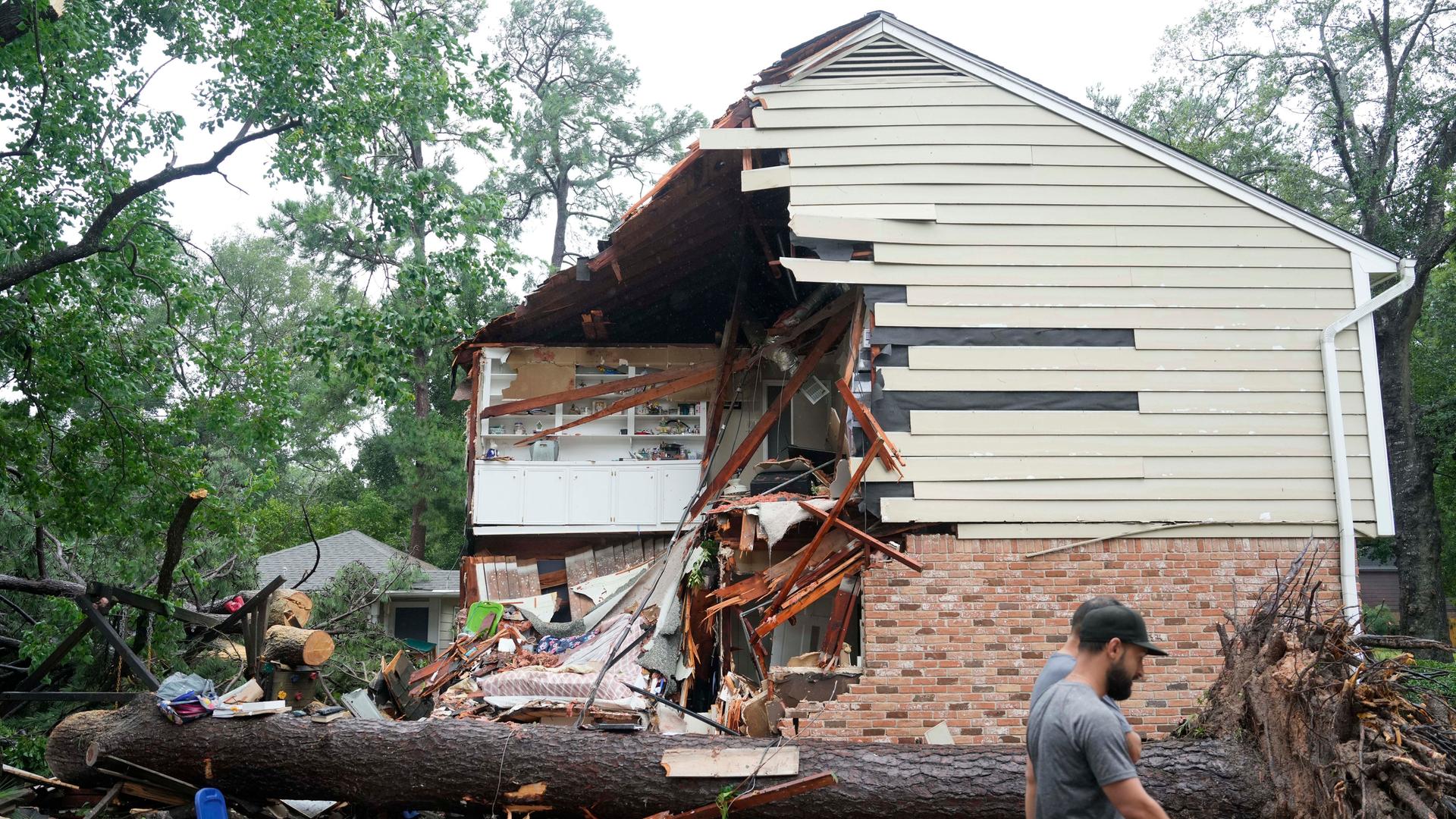Menschen versammeln sich vor einem Haus in Houston, das durch den Hurrikan Beryl beschädigt wurde. 