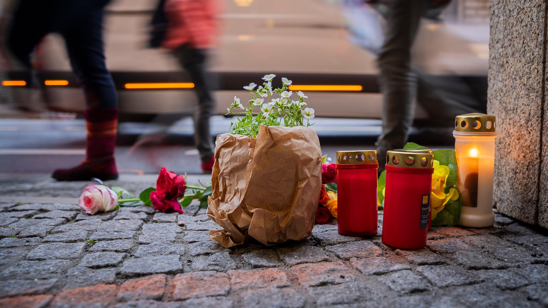 Blumen und Kerzen liegen bei einer Mahnwache nach einem Verkehrsunfall an einer Straße. Blumen und Kerzen liegen bei einer Mahnwache nach einem Verkehrsunfall an einer Straße.