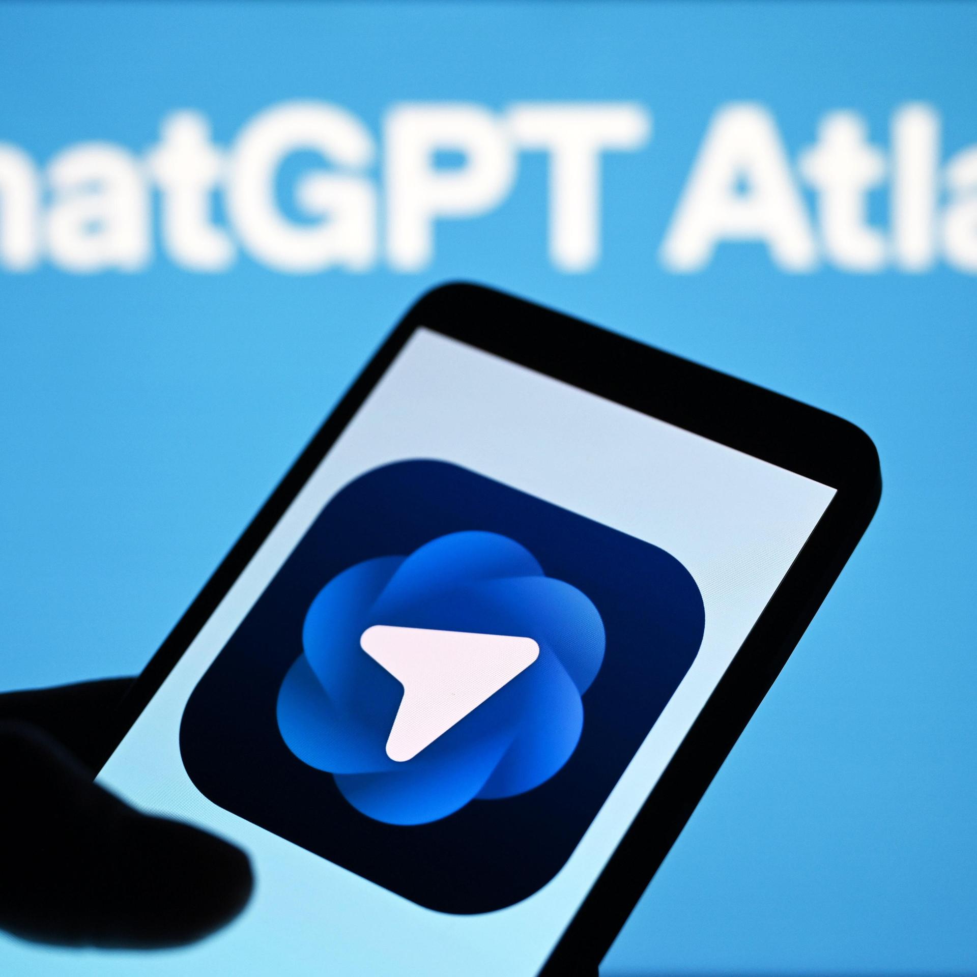 Abgebildet ist der Schriftzug "ChatGPT Atlas" sowie eine Hand, die ein Smartphone hält. Auf dem Display ist das Logo des KI-Browsers von OpenAI zu sehen.