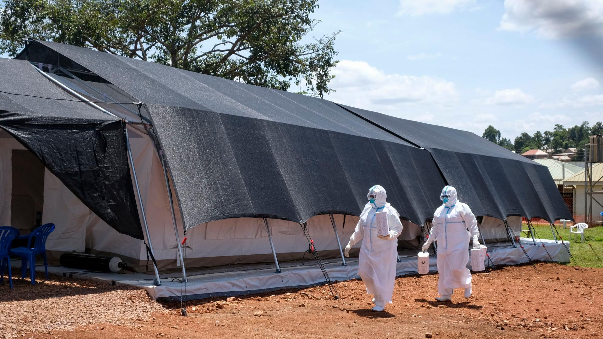 Uganda, Mubende: Zwei Ärzte in Schutzanzügen gehen zum Ebola-Isolationsbereich des Mubende Regional Referral Hospital.