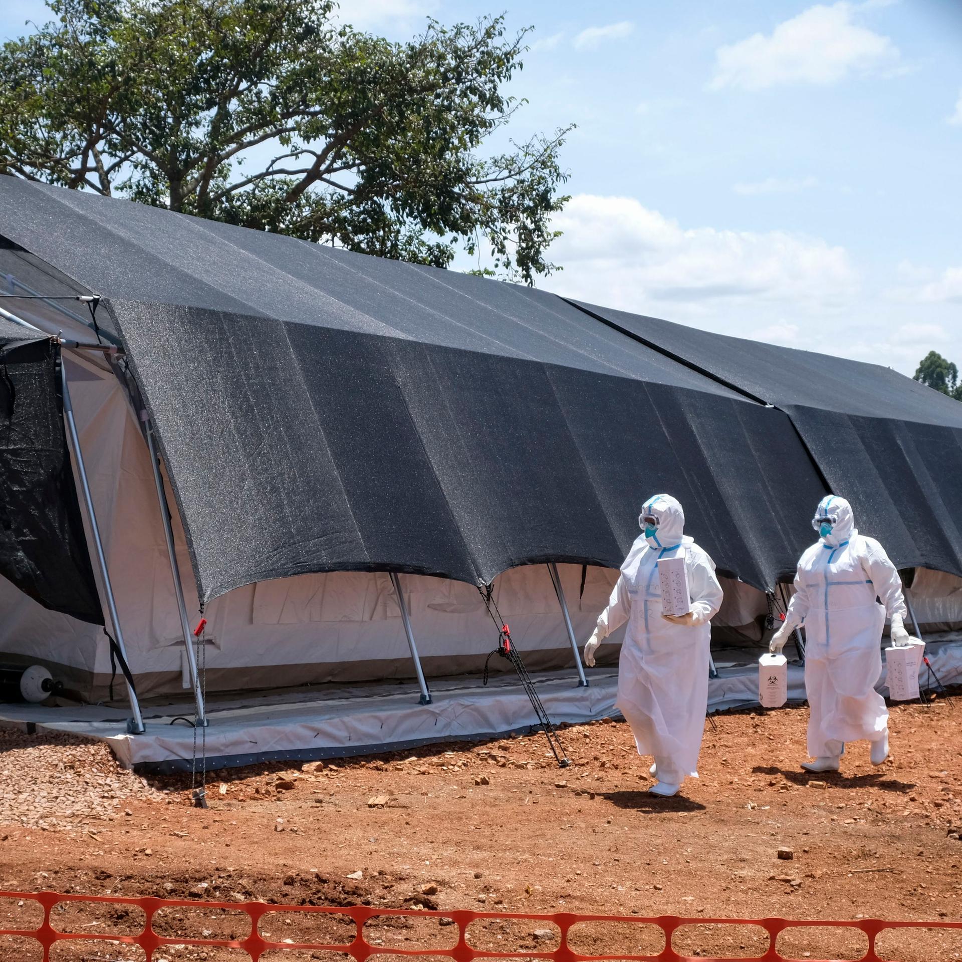 Uganda, Mubende: Zwei Ärzte in Schutzanzügen gehen zum Ebola-Isolationsbereich des Mubende Regional Referral Hospital.