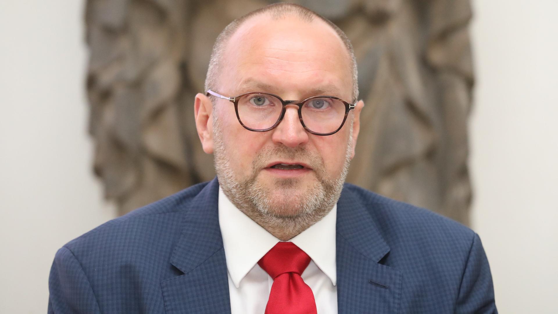 Thomas T. Müller, Chef der Luther-Museen in Sachsen-Anhalt, mit Brille, Anzug und roter Krawatte.