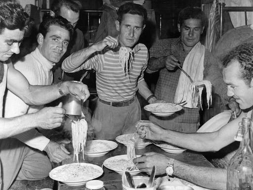 Italienische Arbeitnehmer essen 1960 in ihrer Unterkunft Spaghetti.