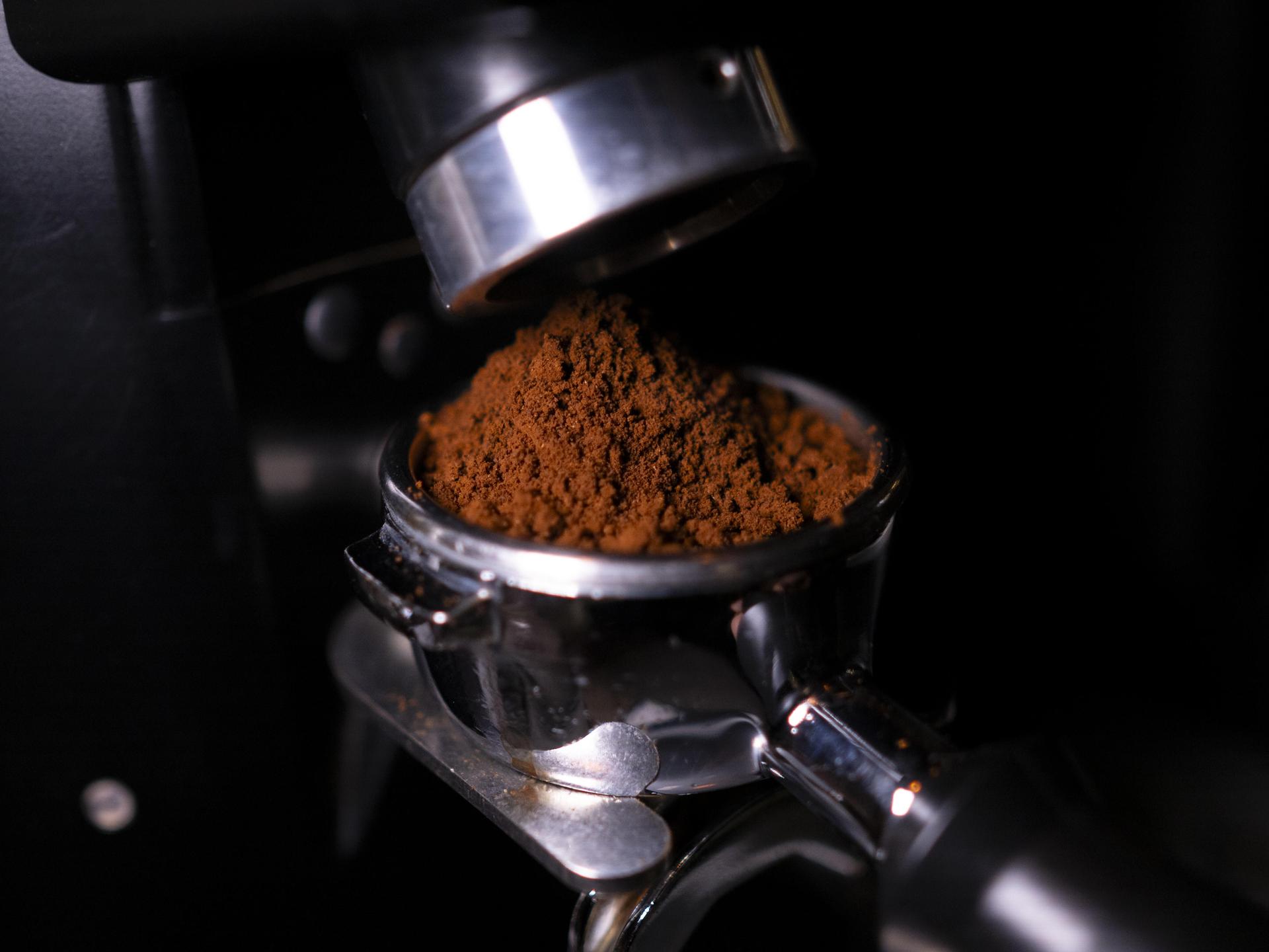 Eine Siebträgermaschine wird mit Espresso befüllt.