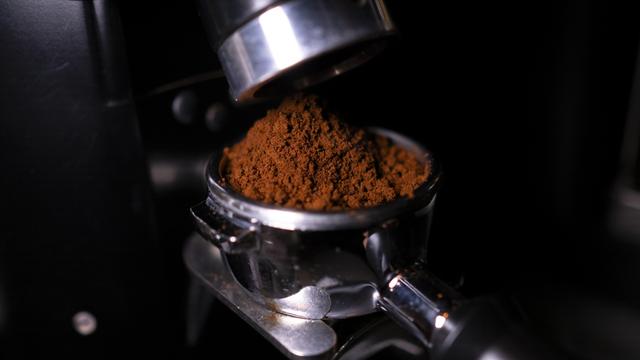 Eine Siebträgermaschine wird mit Espresso befüllt.