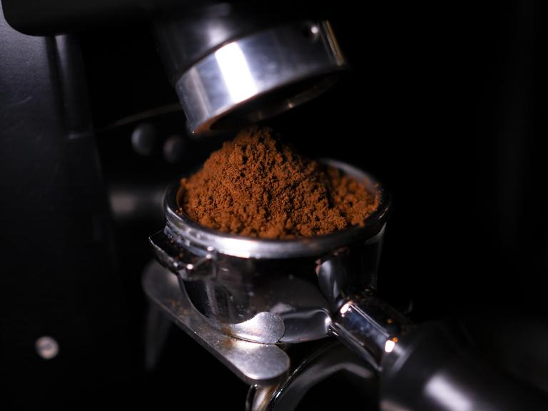 Eine Siebträgermaschine wird mit Espresso befüllt. Eine Siebträgermaschine wird mit Espresso befüllt.