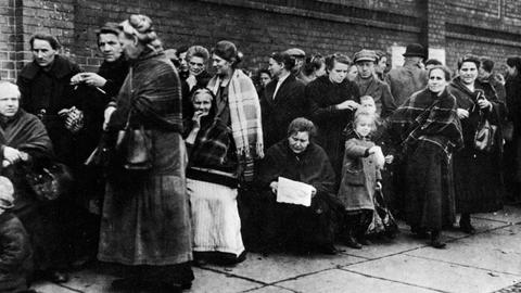 Menschen stehen im Jahr 1923 Schlange an einer Ausgabe für Fleisch.
