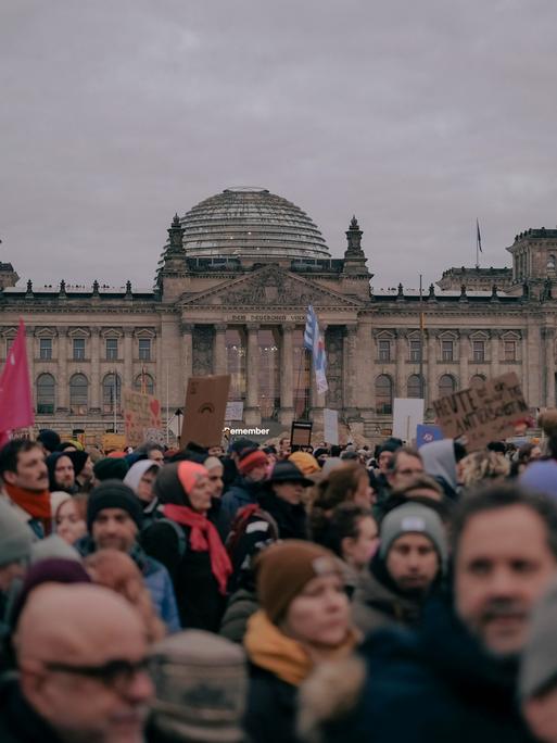 Vor dem Reichstagsgebäude in Berlin sind viele Menschen und demonstrieren. Es ist ein Protest gegen die Kooperation der CDU/CSU mit der AfD. 