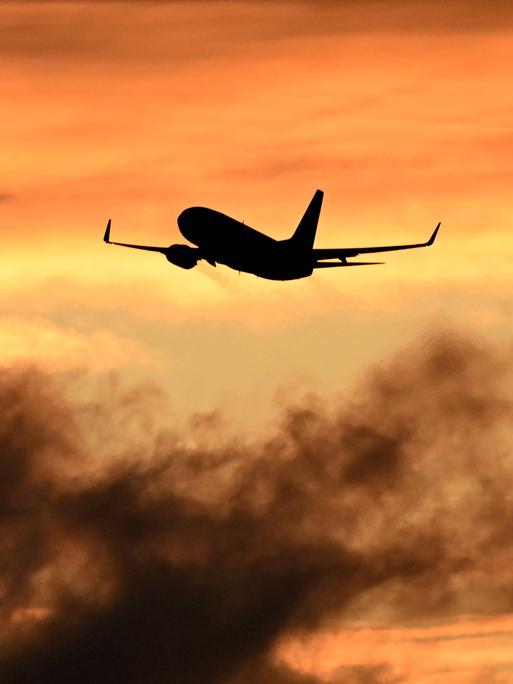 Ein Flugzeug beim Start vor Himmel bei Sonnenuntergang. Ein Flugzeug beim Start vor Himmel bei Sonnenuntergang.