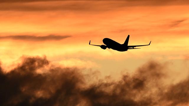 Ein Flugzeug beim Start vor Himmel bei Sonnenuntergang.