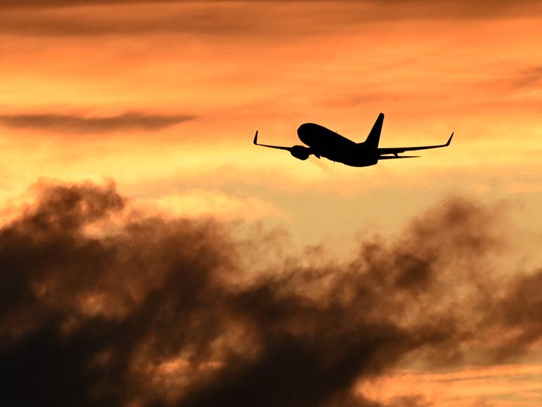 Ein Flugzeug beim Start vor Himmel bei Sonnenuntergang. Ein Flugzeug beim Start vor Himmel bei Sonnenuntergang.