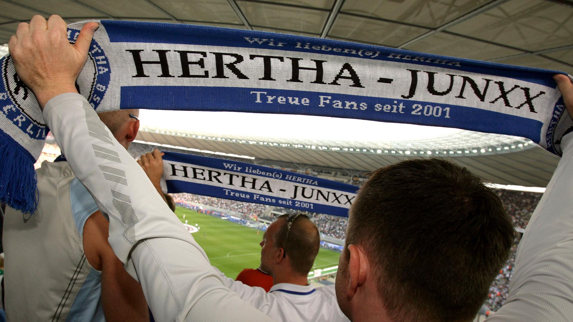 Ein Mann des schwul-lesbischen Fanklubs "Hertha-Junxx" von Hertha BSC Berlin hält im Olympiastadion Berlin einen Schal seines Fanklubs in die Luft. 