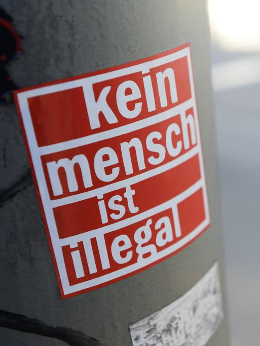 "Kein Mensch ist illegal"-Aufkleber in Hamburg klebt an einer Säule