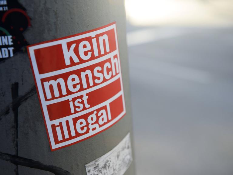 "Kein Mensch ist illegal"-Aufkleber in Hamburg klebt an einer Säule