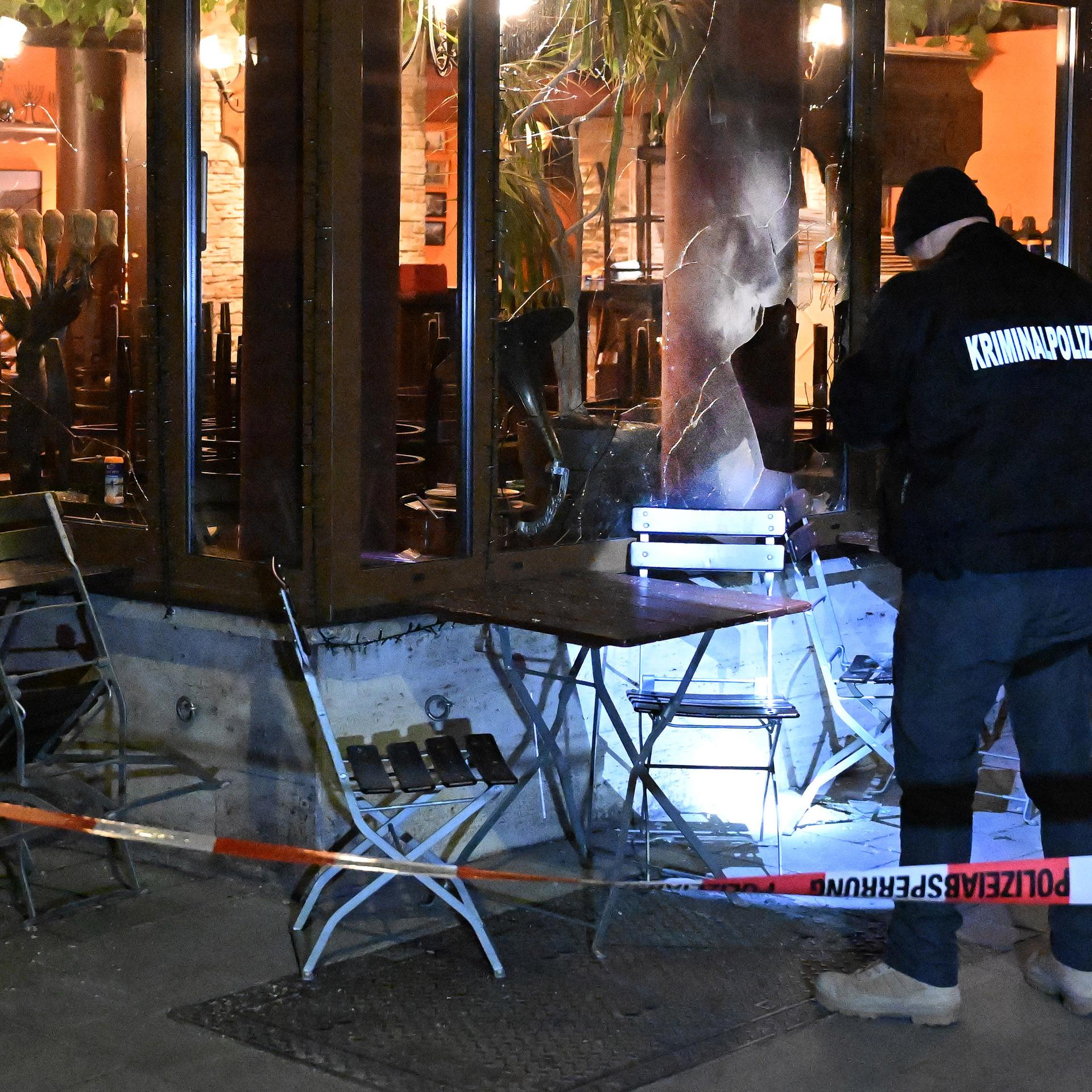 München: Ein Kriminalbeamter steht mit einer Taschenlampe vor einem israelischen Restaurant.